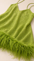 Close-up of green shimmer fabric and feather hem detail