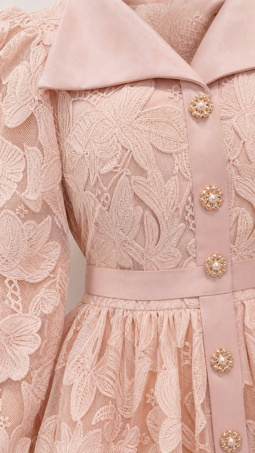 Close-up detail of lapel collar and floral lace texture on pink dress