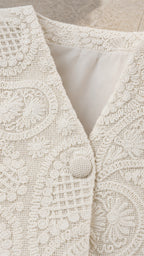 Close-up detail of cream textured fabric and button