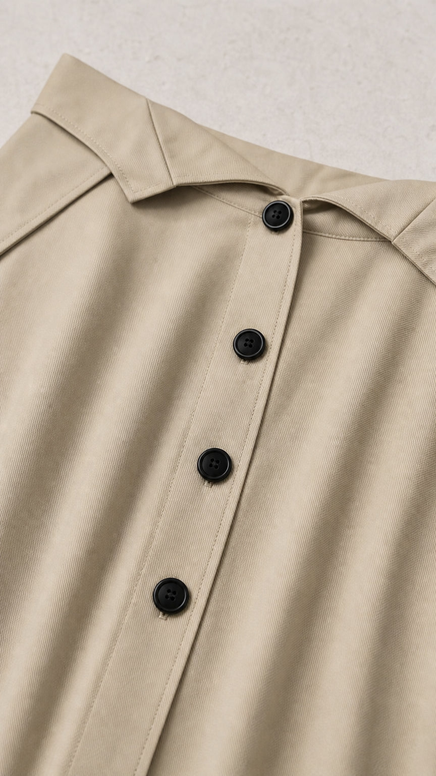 Close-up detail of button placket and waistband on khaki skirt