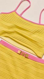 Close-up detail of yellow ribbed fabric and contrast pink trim