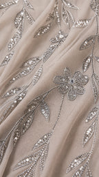 Close-up fabric detail showing intricate sequin vine and flower embroidery on mesh