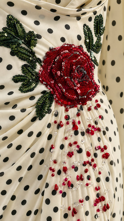 Close-up detail of 3D red rose embroidery and beading on polka dot gown
