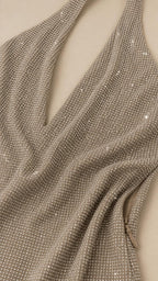 Close-up fabric texture detail of shimmering rhinestone halter dress
