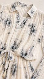 Close-up detail of collar, buttons, and pleated texture on ivory dress