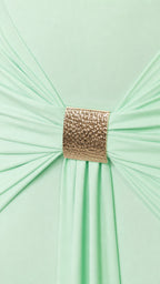Close-up of gold metallic buckle gathering fabric on the dress