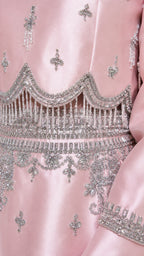 Close-up detail of silver beadwork on pink satin dress