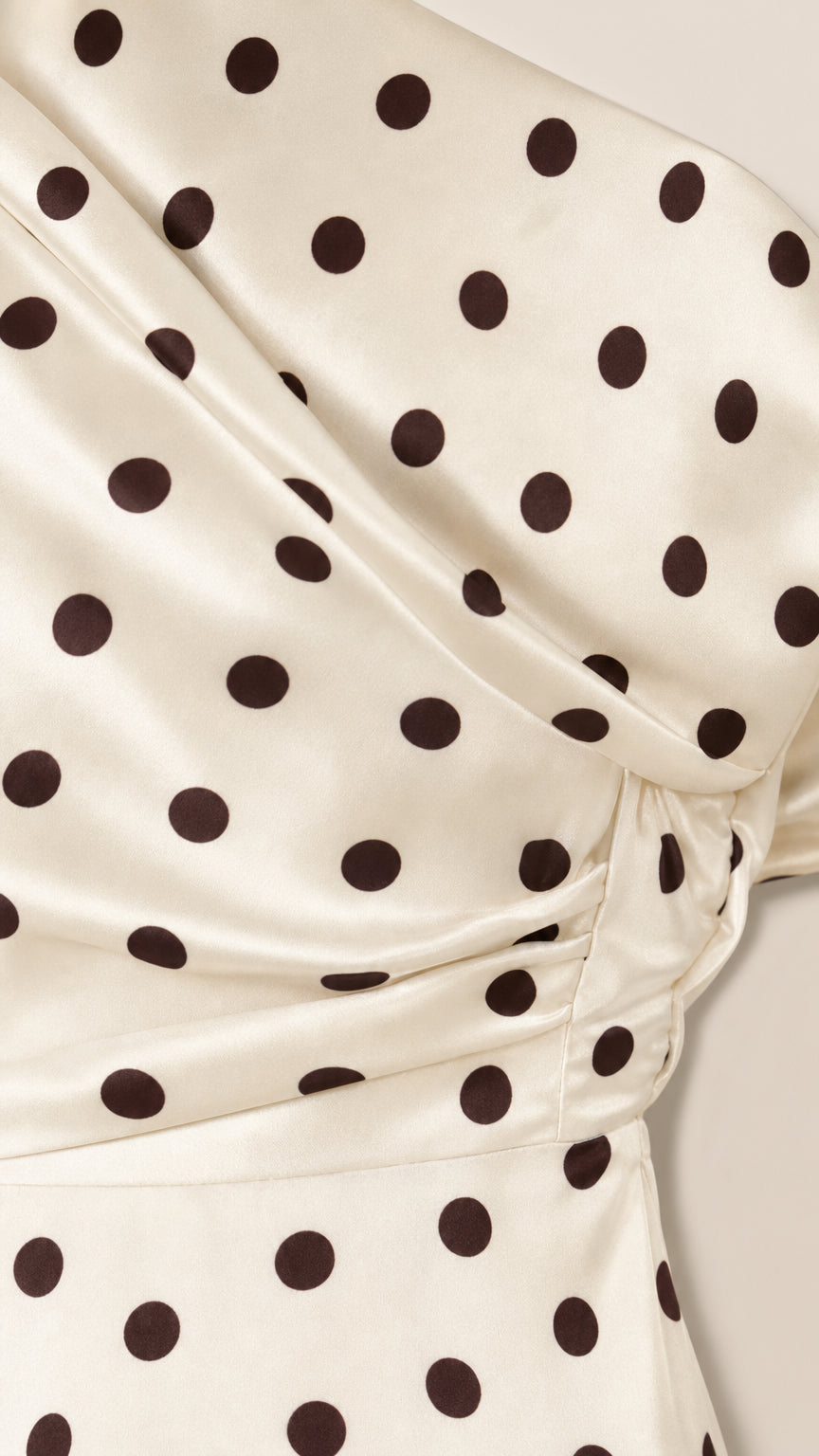 Close-up detail of cream and black polka dot fabric and drape