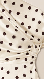 Close-up detail of cream and black polka dot fabric and drape