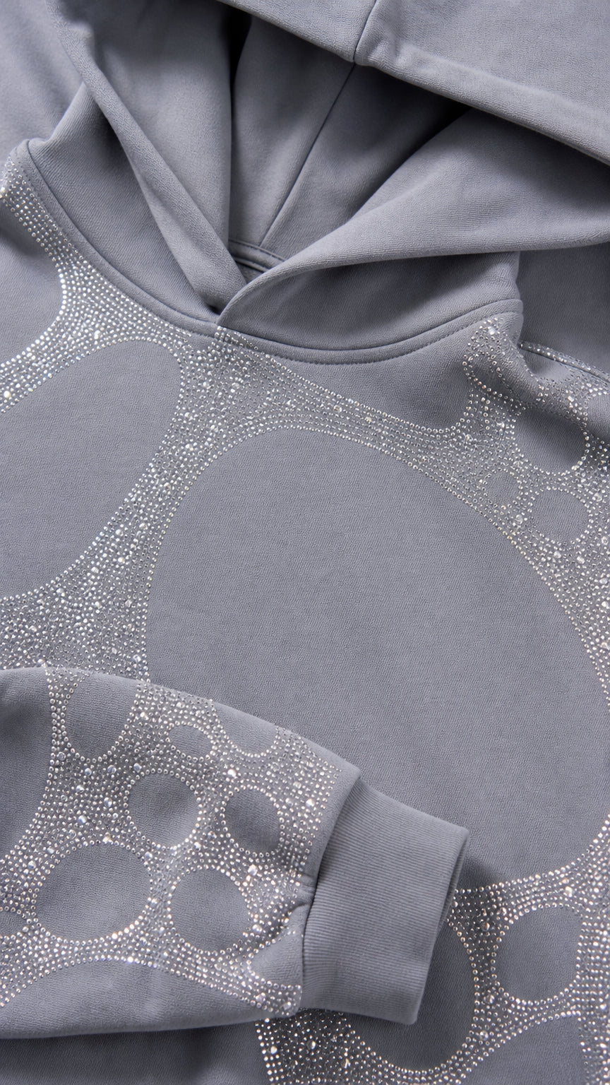 Close-up detail of grey hoodie hood and rhinestone graphic fabric