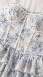 Close-up detail of white and blue floral bustier bodice with ruffles