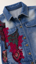 Close-up detail of denim vest collar and red floral embroidery