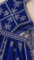 Close-up of embroidery and side cutout detail on royal blue dress