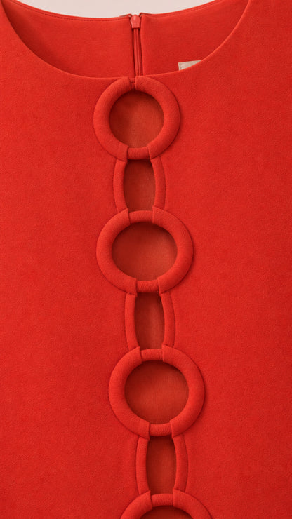 Close-up of the front ring cutout details on red dress fabric