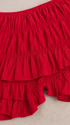 Close-up of the red crinkled fabric and layered ruffle shorts