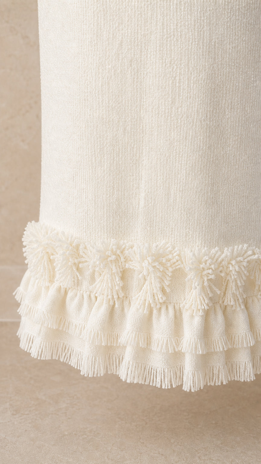 Close-up detail of the fringe hem on the white tweed maxi skirt
