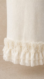 Close-up detail of the fringe hem on the white tweed maxi skirt