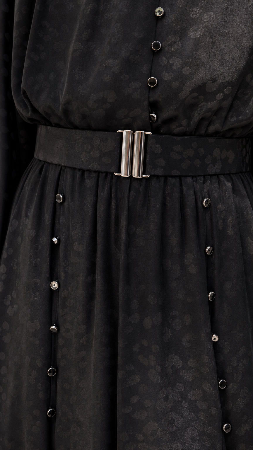 Close-up of black dress belt and button details