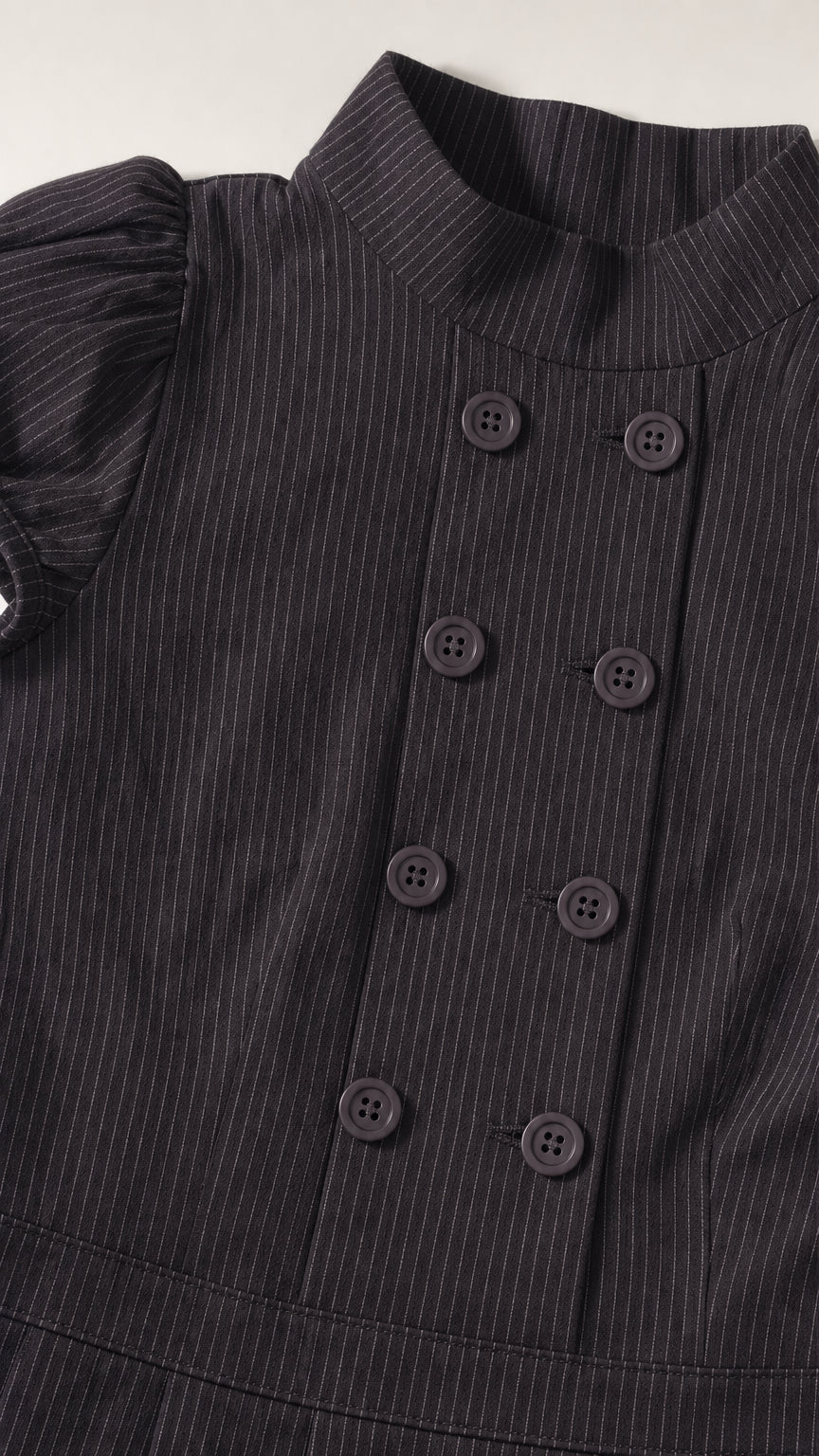 Close up of mock neck and double breasted buttons on black dress
