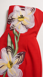 Close-up detail of floral applique on red dress