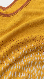 Close-up detail of yellow knit texture and neckline