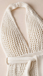 Close-up detail of ivory knit texture and tie belt