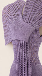 Close-up detail of the knit texture, V-neck, and attached scarf