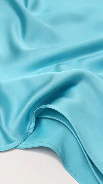 Close-up texture view of smooth cyan satin fabric