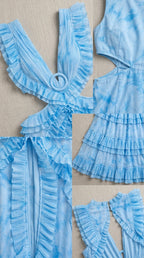 Close-up details of fabric, ruffles, and ring accent on light blue dress