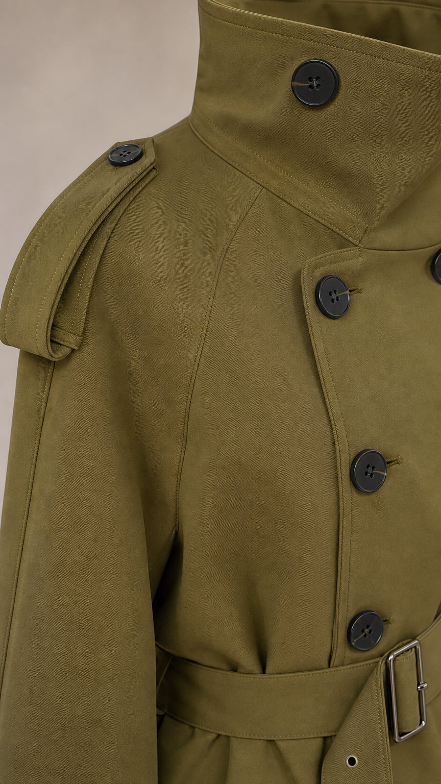Close-up detail of khaki trench jacket collar, buttons, and epaulets
