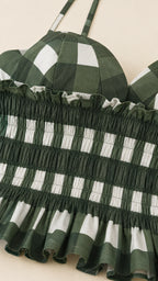 Close up of green gingham smocked bodice and straps