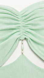 Close-up of ruched bodice and beaded detail on mint green dress