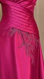 Close-up of pleated bodice and bead embroidery on fuchsia gown