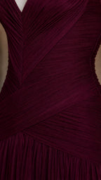 Close-up detail of textured fabric and criss-cross bodice ruching on burgundy dress