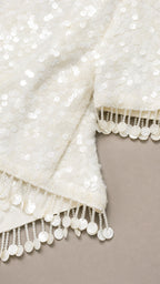 Close-up of white sequin fabric and fringe trim