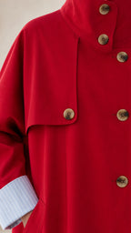 Close-up detail of buttons and collar on the red trench coat