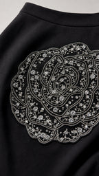 Close-up of intricate rhinestone and bead rose applique on black skirt