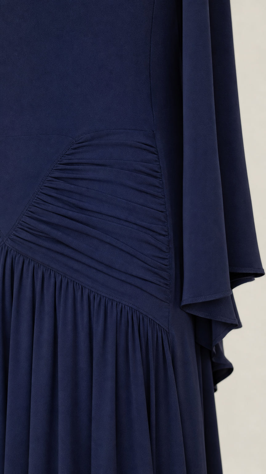 Close-up detail of ruched waist and textured fabric on navy maxi dress