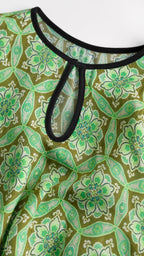 Close up of keyhole neckline and green floral fabric detail