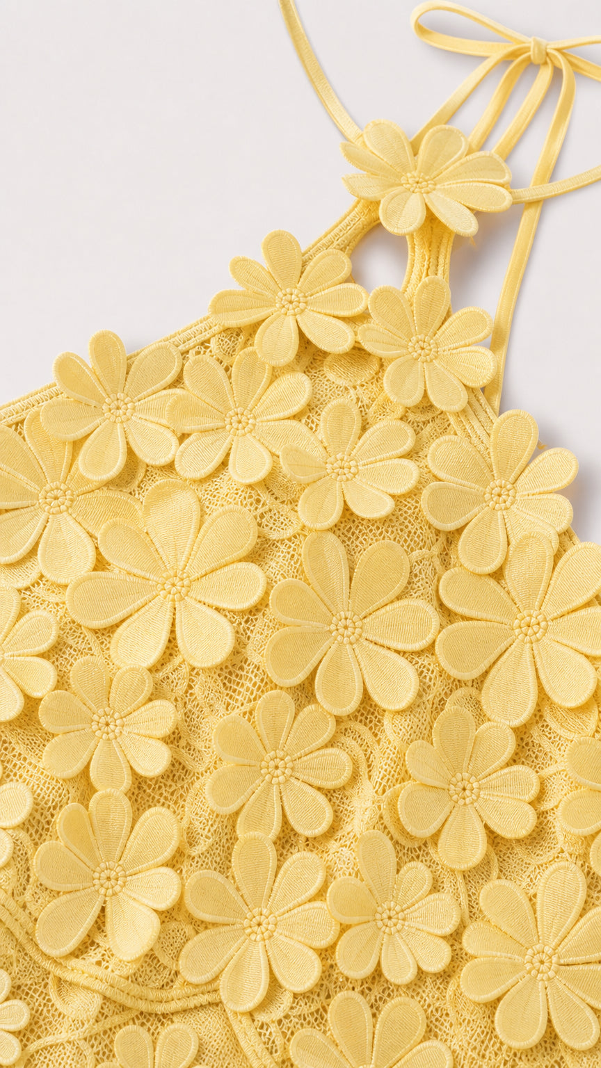 Close-up detail of yellow 3D floral appliques and halter strap