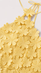 Close-up detail of yellow 3D floral appliques and halter strap