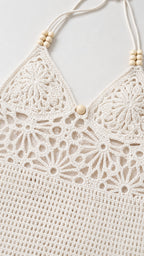 Close-up detail of white crochet halter neckline with wooden beads