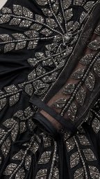 Close up of intricate metallic leaf beadwork on black evening gown