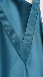Close-up detail of V-neckline and fabric texture on teal satin dress