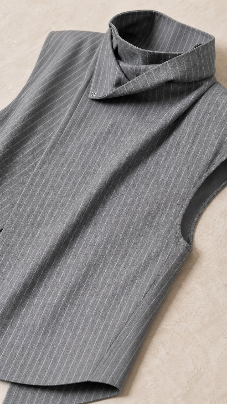 Close-up detail of grey pinstripe fabric and high collar design