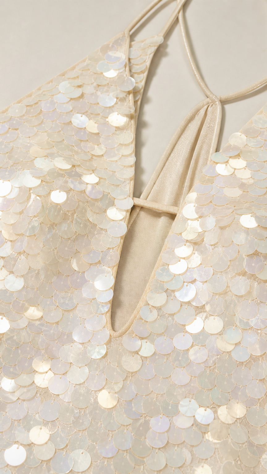 Close-up detail of white sequin texture and plunging neckline
