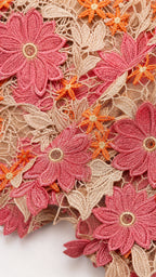 Close-up detail of pink and orange floral lace fabric