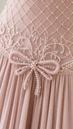 Close-up detail of intricate beadwork and waist bow on bodice