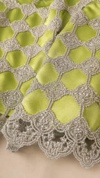 Close-up detail of metallic lattice beadwork and scalloped hem