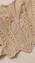 Close up fabric texture view of geometric crochet lace pattern in beige